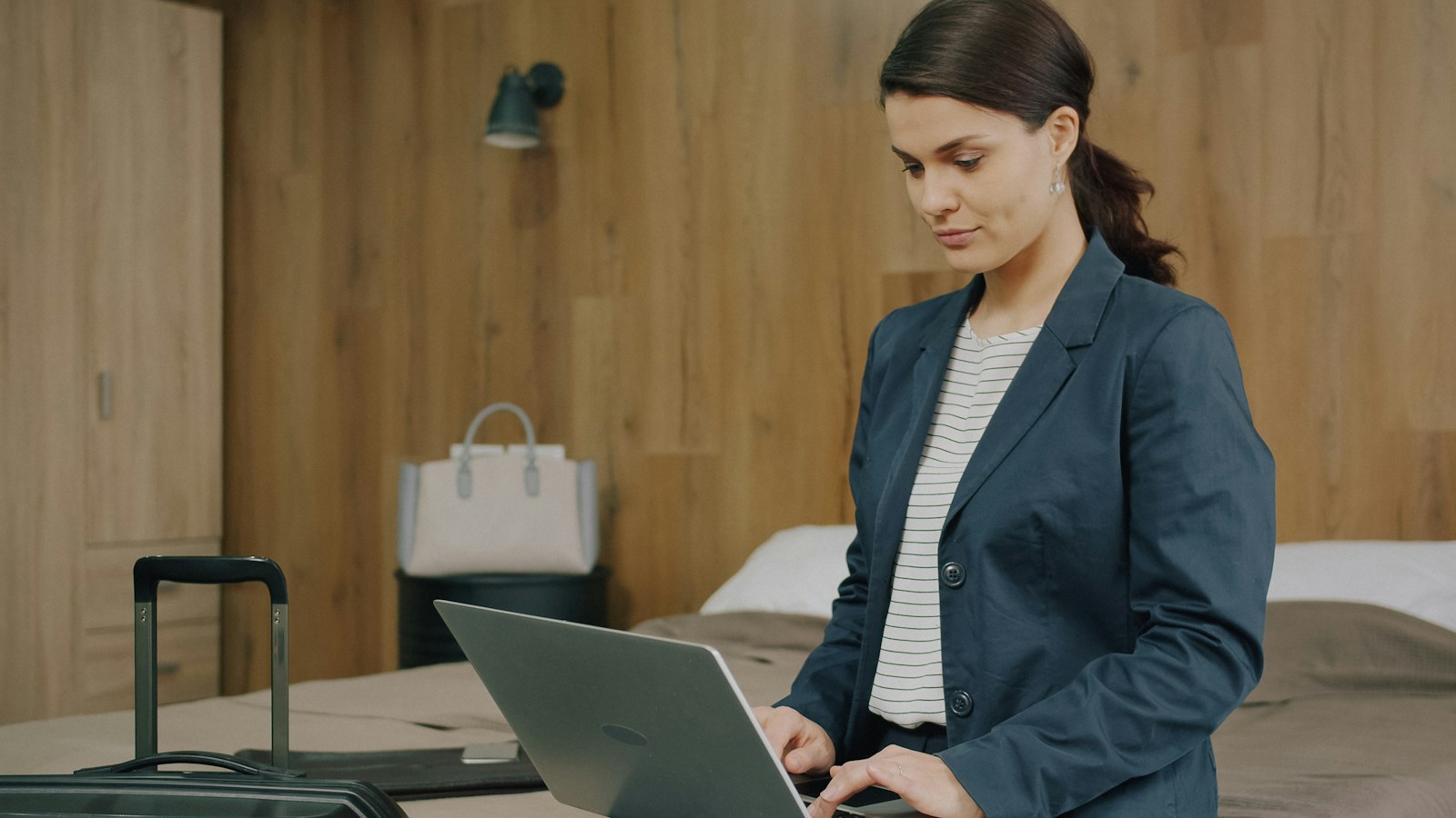 Immigrant woman working on a laptop while travelling, representing financial planning and building wealth abroad